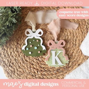 Könnte beinhalten: Zwei Christbaumschmuck mit Schleifendetails. Einer ist olivgrün mit weißen Akzenten und bunten Punkten. Der andere ist hellgrün mit dem Buchstaben "K" und einer rosa Schleife. Der Text "coquette tree with easy score designs" ist sichtbar.