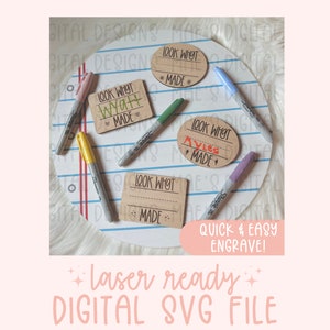 May include: Four wooden tags with the text "Look What I Made" on them. The tags are in different shapes and sizes. The tags are on a white surface with blue and red lines.