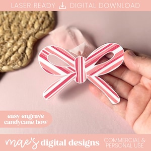 May include: A candy cane bow with red and white stripes, held by a hand. The bow is a digital design, laser-ready, and easy to engrave. The text "mae's digital designs" and "commercial & personal use" are also visible.