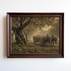 May include: Framed print of a pastoral scene featuring a horse-drawn cart laden with apples in an orchard. The artwork is set in a dark brown wooden frame. The scene is filled with fallen apples and a large, gnarled tree.