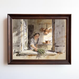 May include: A framed watercolor painting depicting a person in a kitchen reaching through an open window to place a bundle of green herbs on the sill. Copper pots hang on the wall behind them, and a copper pot sits on the counter in the background.