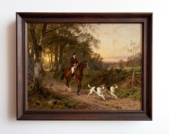 May include: A framed painting depicts a rider on a brown horse, followed by two dogs, on a dirt path through a forest. The artwork features a warm color palette with a sunset in the background. The frame is dark brown.