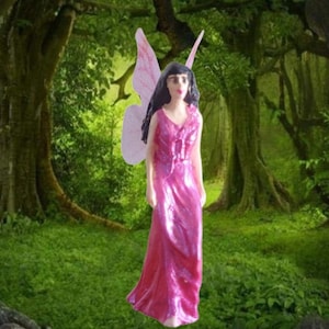 May include: A miniature fairy figurine with pink wings and a long, shimmering pink dress. The fairy has black hair and is set against a backdrop of a lush green forest. The figurine is a decorative item.