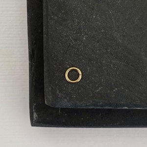 May include: Two black rectangular slate serving trays with a gold metal ring on the top tray.