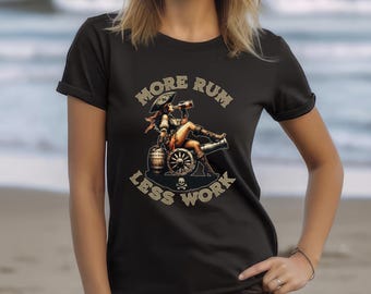 Könnte beinhalten: Schwarzes T-Shirt mit einer goldenen Grafik einer Piratenfrau, die auf einer Kanone sitzt und aus einer Flasche trinkt. Der Text "More Rum Less Work" umgibt die Grafik.