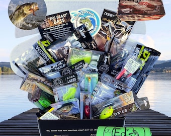Puede incluir: Una caja negra llena de señuelos de pesca, aparejos de pesca y una toalla verde con el texto "Ed's" en ella. La caja está abierta y el contenido se está derramando. La caja está sentada en un muelle de madera.