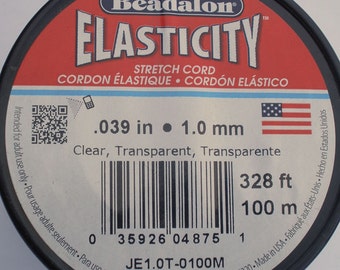 May include: A spool of clear, transparent stretch cord by Beadalon. The label reads "Elasticity" and includes measurements of .039 inches and 328 feet. The product is made in the USA.
