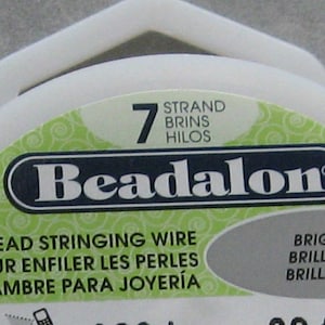 May include: A spool of Beadalon 7 strand bead stringing wire. The label says "Bead Stringing Wire", "Fil Pour Enfiler Les Perles", "Alambre Para Joyer&iacute;a", "Bright", "Brilliant", "Brillante".
