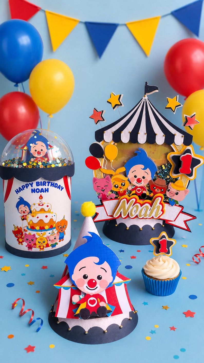 May include: A festive birthday scene with balloons, a cupcake, and decorative elements. The centerpiece features a circus-themed design with the name "Noah" and a "Happy Birthday" message. Colorful stars and confetti add to the celebratory atmosphere.