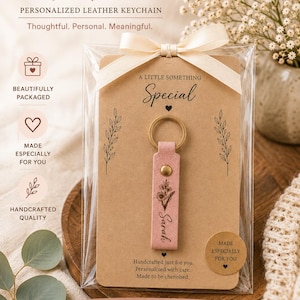 Personalized leather keychain with engraved botanical artwork packaged on a decorative backing card inside a clear sleeve with ribbon. A ready-to-gift keepsake for friends and family.