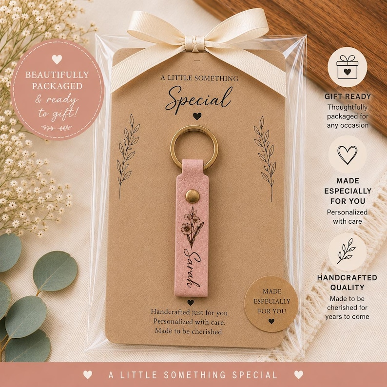 Premium leather birth flower keychain resting on a neutral linen background with natural greenery and wood accents. Lightweight personalized keychain with durable brass key ring.