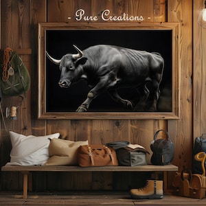 Puede incluir: Un cuadro enmarcado de un toro negro con grandes cuernos sobre un fondo negro cuelga de una pared de madera. Un banco debajo contiene almohadas, bolsos y un par de botas. El texto "Pure Creations" está en la parte superior de la imagen.