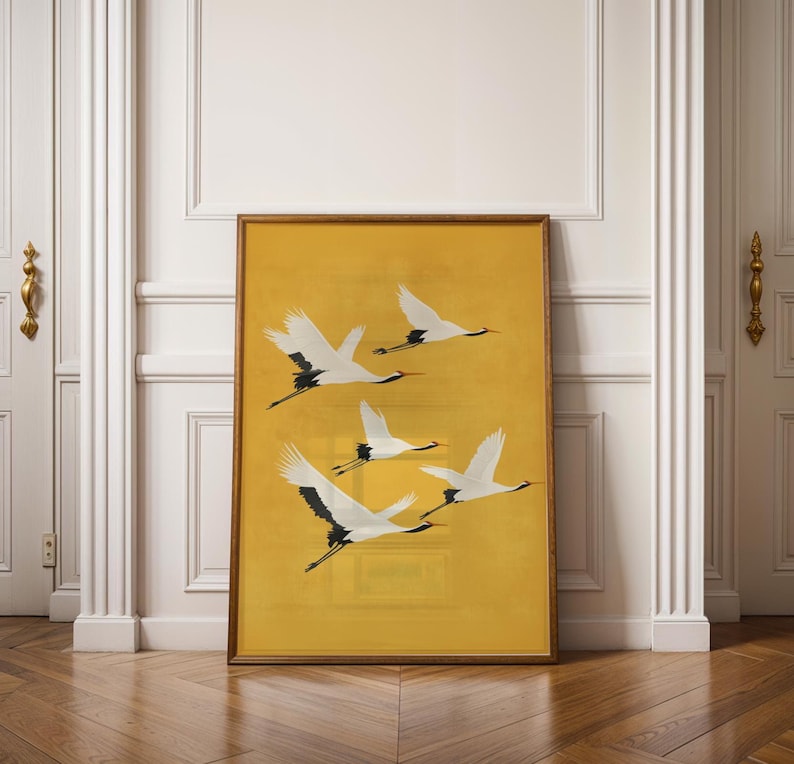 Elegant white cranes flying against a golden yellow background in a Japanese-inspired artwork.