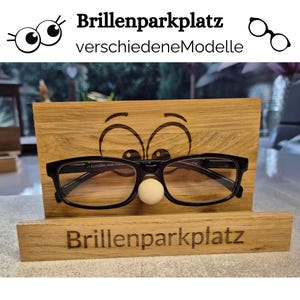 Titelbild zeigt einen Halter aus Eichenholz auf dem 2 Cartoon Augen aufgraviert wurden. Auf der Nase kann die Brille aufgelegt werden. Als Beschriftung ist hier Brillenparkplatz zu sehen. Verschiedene Augen und Beschriftungen zur Auswahl.