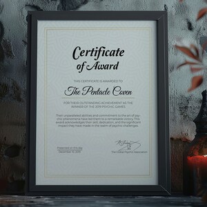 K&ouml;nnte beinhalten: Gerahmte Auszeichnungsurkunde f&uuml;r The Pentacle Coven, Gewinner der Psychic Games 2019. Der schwarze Rahmen umgibt eine Urkunde mit dekorativen R&auml;ndern und Text. Die Urkunde wird am 10. Dezember 2019 pr&auml;sentiert.