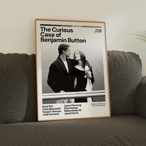 May include: A framed poster featuring the movie "The Curious Case of Benjamin Button." The black and white image shows two people embracing. The poster includes the movie title, cast names, and the number "08."