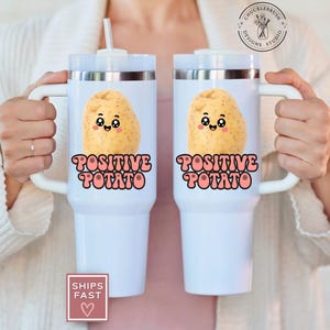 May include: Two white travel mugs with handles, each featuring a smiling potato graphic and the words "POSITIVE POTATO" in a retro font. The mugs have silver rims and white straws.