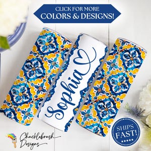 May include: Three white and blue insulated tumblers with a floral design. One tumbler has the name "Sophia" in blue script. The other two tumblers have a blue, yellow, and white floral pattern. The image includes the text "CLICK FOR MORE COLORS & DESIGNS!"