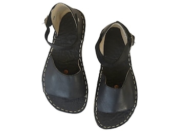 May include: A pair of black leather sandals with ankle straps. The sandals have a simple design and are made of high-quality leather.