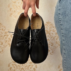 Puede incluir: Un par de zapatos negros de cuero con cordones y punta redonda. Los zapatos tienen una etiqueta que dice "3.1 S.W. Berlin".