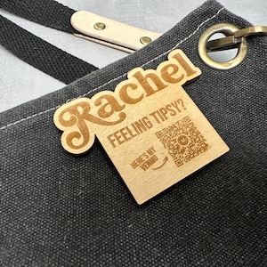 Puede incluir: Una etiqueta de madera con el nombre "Rachel" y el texto "Feeling Tipsy? Here's my Venmo" con un código QR.