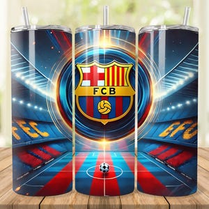 Op de afbeelding: Set van drie roestvrijstalen bekers met een levendig ontwerp met het FC Barcelona-logo en een voetbalstadion. De bekers, elk met een rietje, tonen de kleuren van het team: rood, blauw en goud. Het ontwerp bevat een voetbalveld.