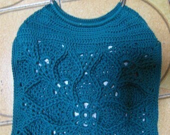 May include: Teal crocheted tote bag with silver metal handles. The bag has a lacy design.