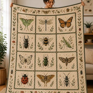 May include: A cream-colored quilt featuring a grid of twelve squares, each displaying a detailed illustration of a different insect, including butterflies, moths, beetles, a dragonfly, a bee, and a mantis, framed by a botanical border of vines.