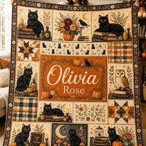 May include: A rectangular quilt featuring a patchwork design with black cats, pumpkins, flowers, books, and an owl. The center panel displays the name Olivia Rose in white script and print text. The border is decorated with a floral pattern.