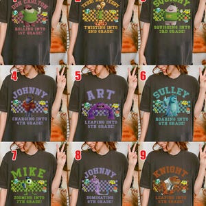 May include: A collection of nine dark grey t-shirts, each featuring a different character and grade level from the animated film Monsters, Inc. The shirts have text like "Rolling into 1st Grade!" and "Zooming into 7th Grade!"