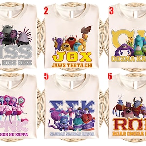 May include: Six cream-colored t-shirts with different monster-themed designs. Each shirt features a group of cartoon monsters and Greek letter-based text. The text includes "HSS ETA HISS HISS", "JOX JAWS THETA CHI", "OOZMA KAPPA", "PNK PYTHON NU KAPPA", "ΣΣΚ SLUGMA SLUGMA KAPPA", and "ROR ROAR OMEGA ROAR".
