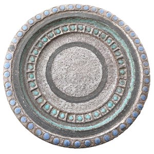 May include: A round, textured, ceramic plate with concentric circles. The plate features a gray base with teal and blue accents. The outer rim has blue dots, while the inner circles have teal squares and gray lines.