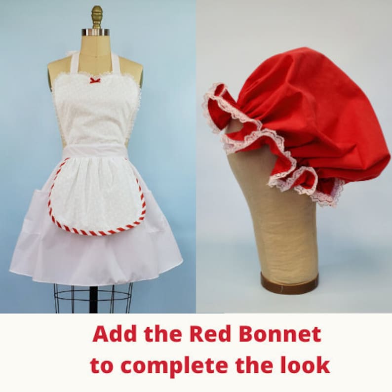 May include: A white apron with red trim and a red bonnet with white lace. The text "Add the Red Bonnet to complete the look" is at the bottom of the image.