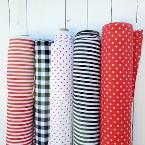 May include: Five rolls of fabric with different patterns. The fabric rolls are red and white striped, black and white checkered, red with white polka dots, black and white striped, and red with white polka dots.