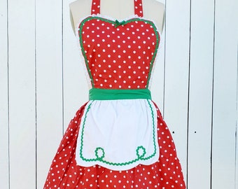 May include: Red and white polka dot apron with a green trim and a white bib. The apron has a halter neck style and a gathered skirt.