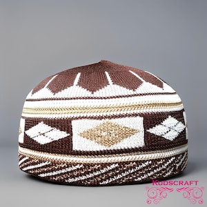 May include: A brown, white, and gold knitted skull cap with geometric patterns. The cap features diamond and rectangular designs, with a striped band at the base. The top is a solid brown colour.