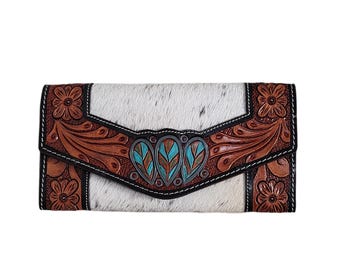 May include: A white and brown leather wallet with a floral design and turquoise accents. The wallet has a flap closure and a black stitching detail.