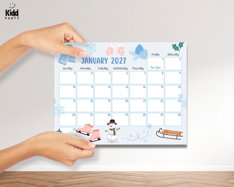 May include: A light blue January 2027 calendar with winter illustrations. The calendar features images of ice skates, mittens, snowflakes, and a snowman. The calendar is held by two hands.