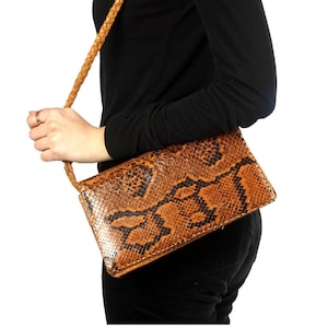 Cartera vintage de piel de serpiente marrón con forma de sobre y bandolera, de los años 60