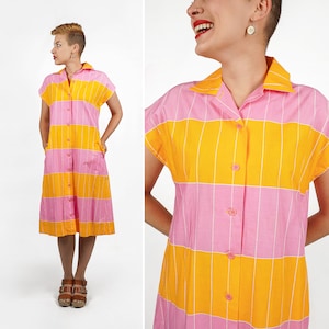 Puede incluir: Vestido camisero con botones y mangas cortas, con rayas horizontales rosas y amarillas. Cuello camisero y tejido ligero. El vestido llega a la rodilla y tiene bolsillos. Prenda de verano.