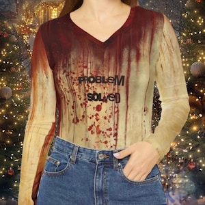 Può includere: Una maglietta a maniche lunghe con un design a schizzi rosso e bianco. La maglietta ha un collo a V e la scritta "Problema risolto" stampata sul davanti.