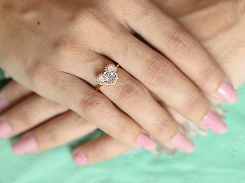 May include: A heart-shaped ring with a large, clear gemstone surrounded by smaller, clear gemstones. The ring is set in rose gold.