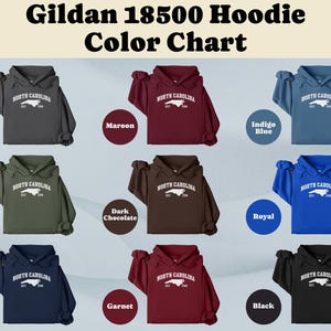 May include: A color chart displaying Gildan 18500 hoodies in various colors, including charcoal, maroon, indigo blue, military green, dark chocolate, royal, navy, garnet, and black. Each hoodie features a white graphic with "NORTH CAROLINA" and the state outline.