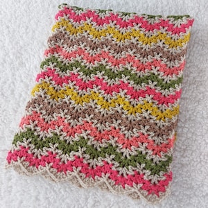 May include: A multi-colored crocheted baby blanket with a scalloped edge. The blanket is made with stripes of pink, green, brown, and yellow yarn.