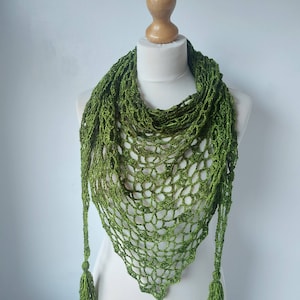 May include: A green crocheted shawl with a triangular shape and tassels on the ends.