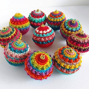 May include: Ten colorful crocheted Christmas ornaments with a variety of patterns and colors, including red, green, blue, yellow, and purple.
