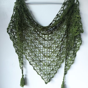 May include: A green crocheted shawl with a lacy pattern and tassels on the ends.
