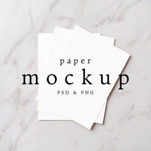 May include: A stack of three blank white rectangular paper sheets arranged in a layered, overlapping formation. The top sheet features black text centered in the middle that reads paper mockup PSD & PNG in a clean, serif and sans-serif font style.