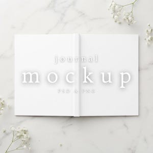 Puede incluir: Un diario blanco abierto con un diseño de página en blanco. El texto "journal mockup" está centrado en una fuente gris claro, con "PSD & PNG" impreso en texto más pequeño debajo. El diario se muestra sobre una superficie de mármol blanco.