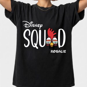 May include: Black t-shirt with the text "Disney SQUAD" in white, featuring a cartoon chicken wearing sunglasses. The name "ROSALIE" is printed below the chicken graphic.